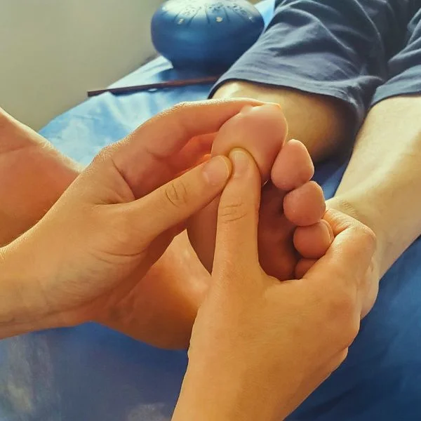 reflexologia podal en bogota, tocando punto en dedo pulgar del paciente