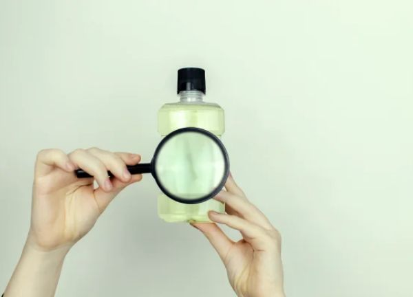 ingredientes ocultos en los cosmeticos con lupa al frasco